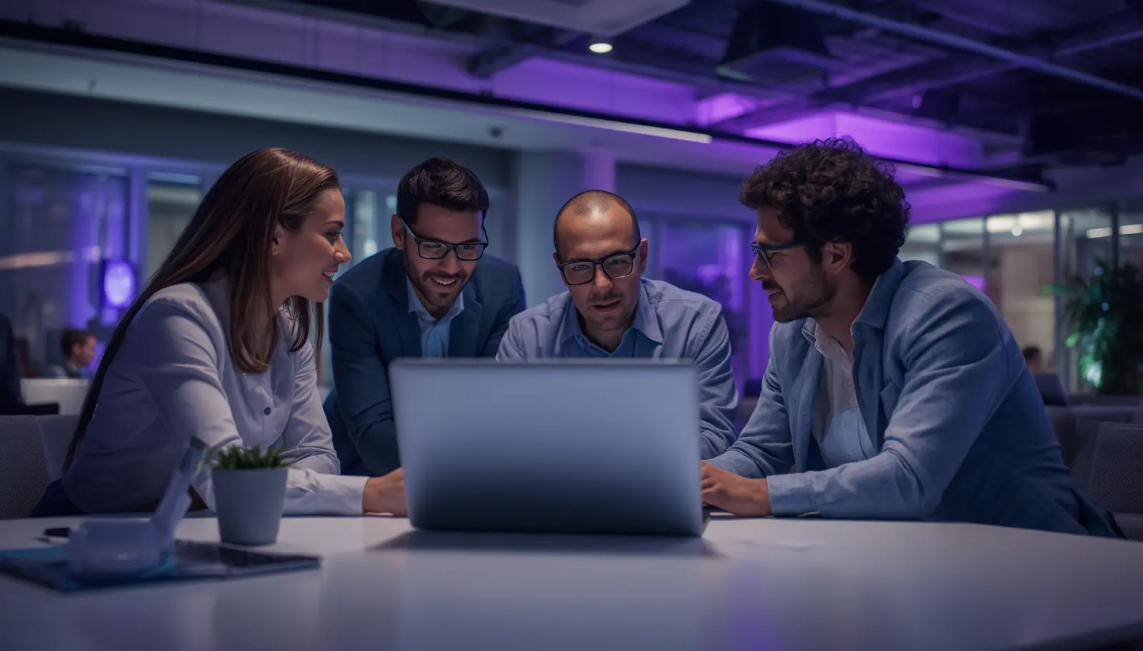 Enterprise sales team watching a video briefing on a laptop in a modern office