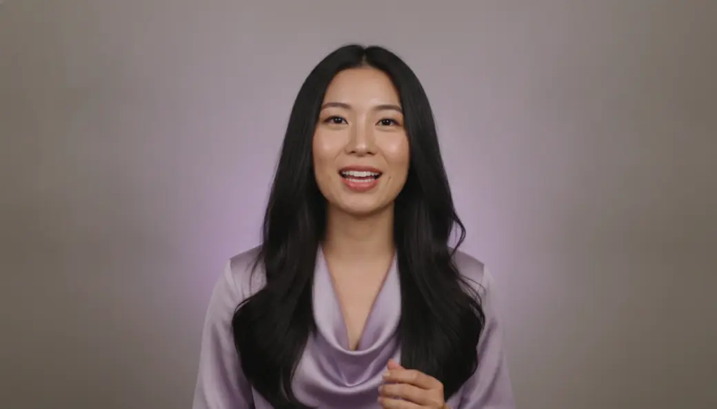 An AI talking avatar in a lilac blouse speaking typed text in a captioned video made with Pictory