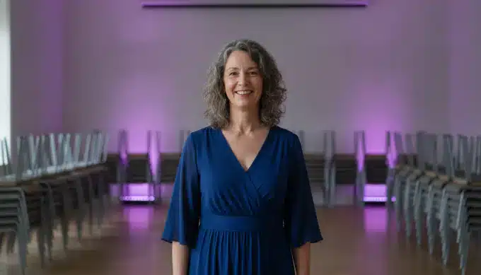 A choir director in a rehearsal hall in a lyric video made for her choir