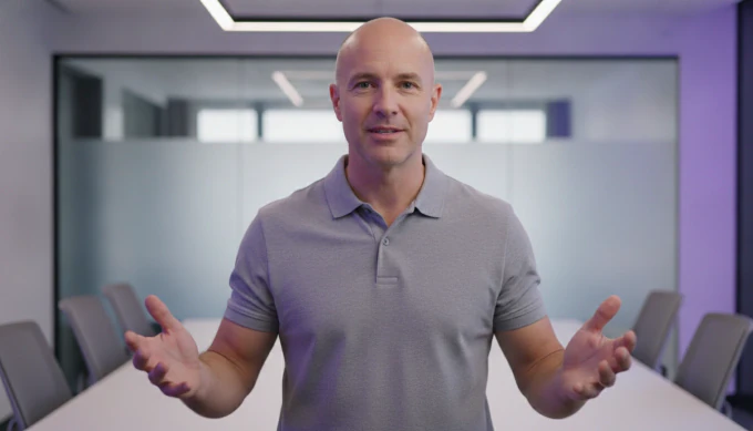 A corporate trainer explaining with open hands in a training video made from his workshop slides