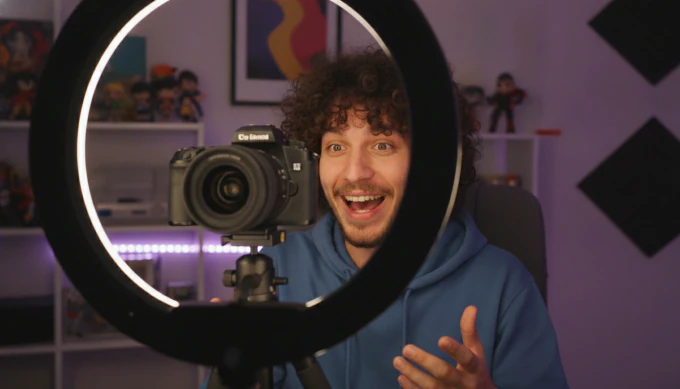 Creator with his camera and ring light, his video resized to a captioned vertical Short for YouTube, TikTok and Reels