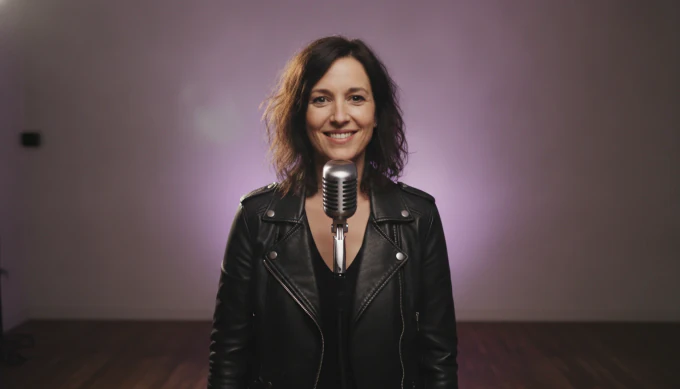 An independent artist at a microphone in a music video made from her new single