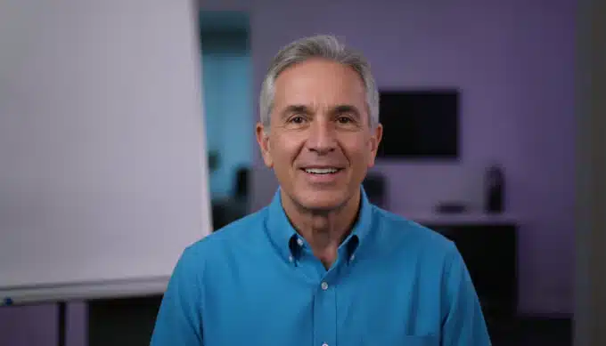 An online course instructor at a whiteboard in a lesson video with AI captions from Pictory