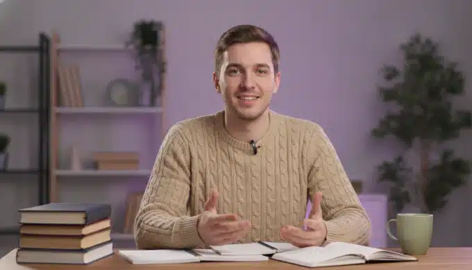 An online tutor at a desk in a lesson video with subtitles translated by Pictory
