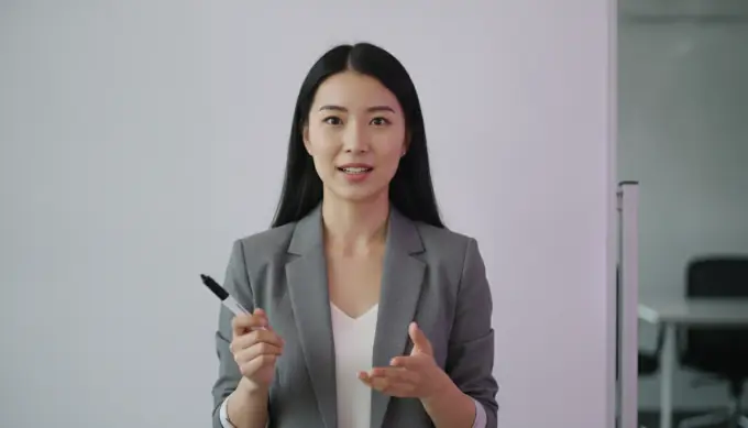 An operations specialist explaining a process near a whiteboard, in a training video made from a procedure