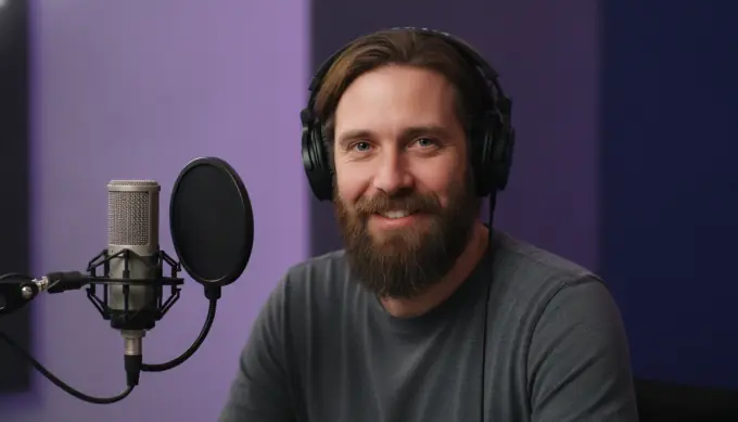 A podcast host at his microphone in a video clip repurposed from a podcast episode