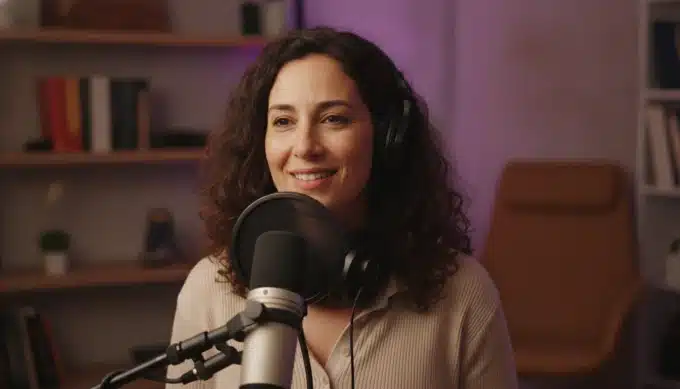 A podcast host at a microphone in a home studio in a video podcast with captions from Pictory