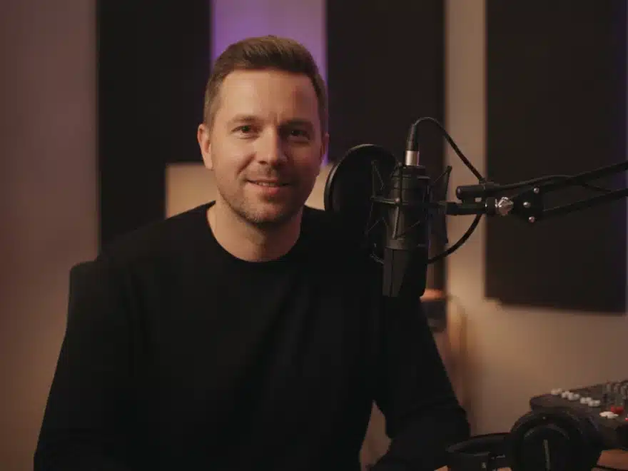 A podcast host at a microphone recording a sample for his voice clone in Pictory