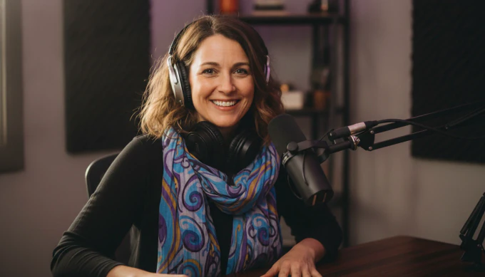 A podcast host in headphones at her microphone, with her audio recording turned into a captioned video by Pictory 3