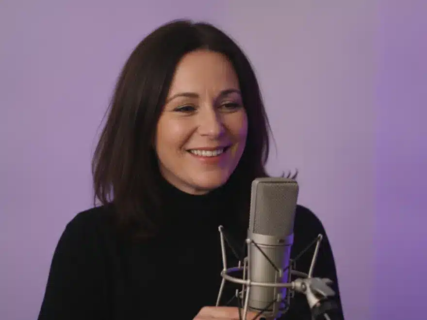 A podcaster at her microphone after removing filler words and silences from her recording in Pictory