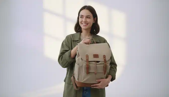 A product designer showing a backpack in a studio in a launch video dubbed by Pictory