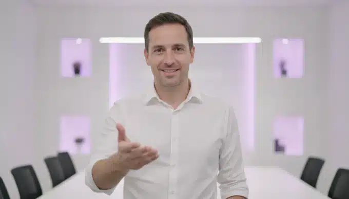 A product marketer presenting a demo in a meeting room in a video captioned by Pictory