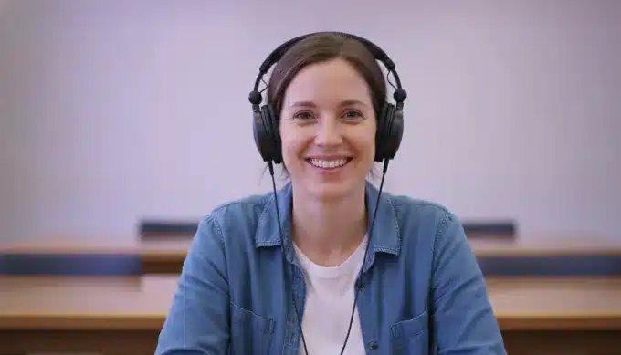 A researcher with headphones in a library in a video made from a recorded interview