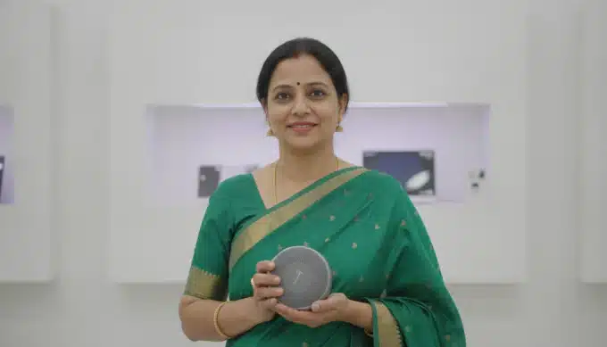 A sales lead holding a wireless speaker in a Mumbai showroom in a demo video translated into Hindi by Pictory