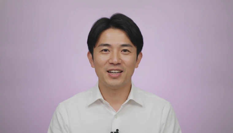 A smiling man in a white shirt speaking to camera, with a caption across the bottom of the video