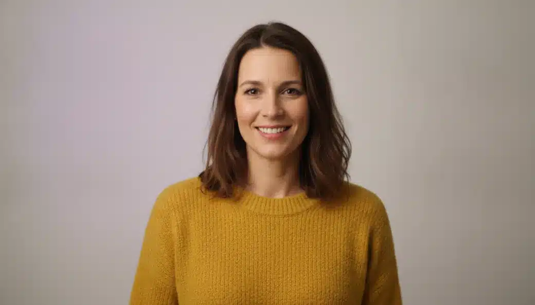A social media manager smiling at the camera in a bright studio, in a vertical video made with Pictory