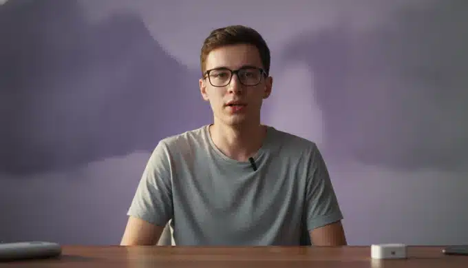 A tech reviewer at his desk in a YouTube video with subtitles generated by Pictory