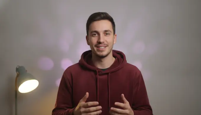 A video creator talking to the camera in a YouTube video that uses custom AI-generated visuals