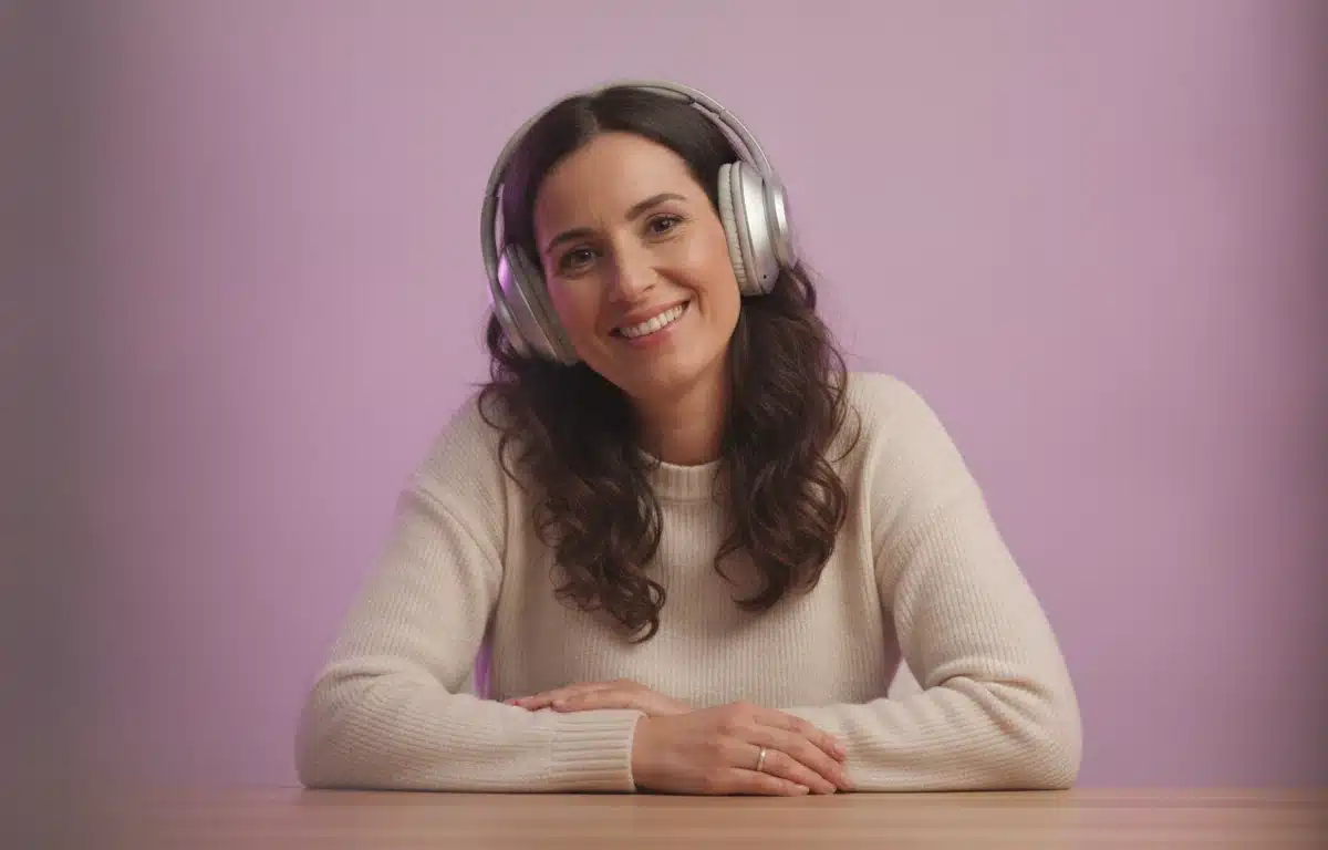 A video producer at her desk with headphones listening to a video dubbed into Spanish in Pictory