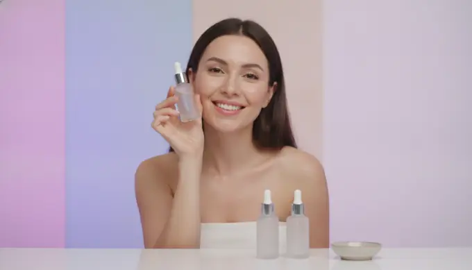 A woman smiling with skincare products in a video made from a product page link